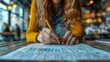 © Emiliia - A student sits at a table in a cafe, using a pencil to mark off tasks on a to-do list.