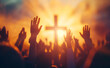 © Curioso.Photography - Hands raised in worship in front of a cross at sunset.
