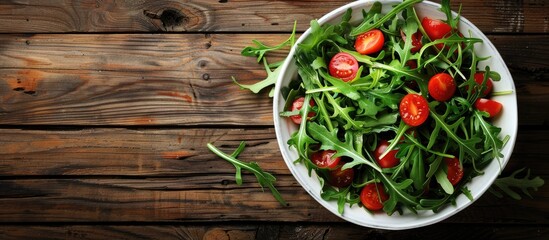 Wall Mural - Fresh salad with arugula and cherry tomatoes on a rustic wooden table showcasing a copy space image