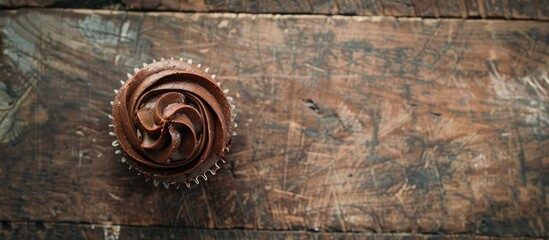 Poster - Rustic top view of a chocolate cupcake on a table with copy space image for a delightful meal or snack