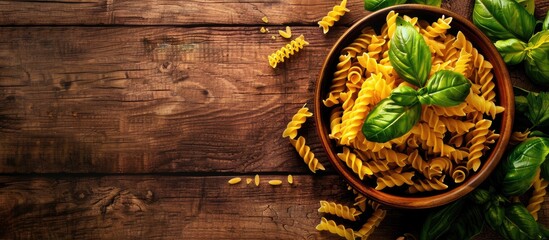 Aufkleber - Italian cuisine displayed with dry pasta and fresh basil on a rustic wooden background captured from above with ample copy space image