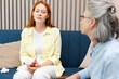 © Maria Vitkovska - Sad, red head woman crying during therapy session with psychologist sitting on sofa