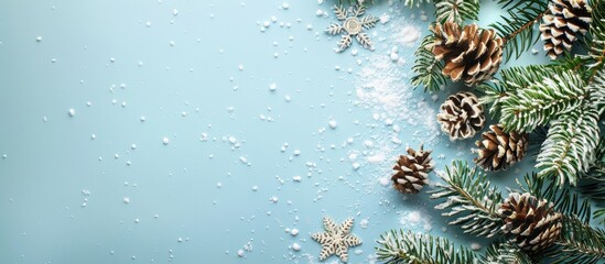 Poster - Snowy fir tree branch snowflakes and fir cones on light blue backdrop with copy space image for Christmas winter holidays Merry Christmas or Happy New Year concept