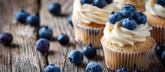 Sticker - Fresh cupcakes topped with ripe blueberries displayed on a rustic wooden surface with room for text in the image. Creative banner. Copyspace image