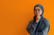 © ammad - Muslim woman wearing hijab glasses thinking yellow advertisement background