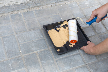 Wall Mural - A person is painting a wall with a roller