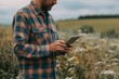 © Iryna - Farmer using a tablet to examine crops in the field, combining modern technology with agronomy.