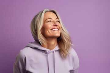 Wall Mural - Portrait of a satisfied woman in her 40s sporting a comfortable hoodie on pastel purple background