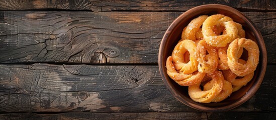 Canvas Print - A top down photo on a wooden table shows traditional Italian Taralli biscuits in a bowl with copy space image