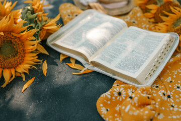 Wall Mural - Bible and sunflowers top view on black background