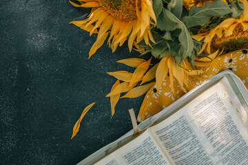 Wall Mural - Bible and sunflowers top view on black background