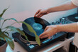 © arthurhidden - Person preparing to play music by putting a vinyl record on a DJ turntable.