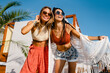© mary_markevich - stylish women friends posing on summer tropical vacation fashion style