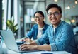 © Cetin - smiling man and woman in casual attire are sitting at an office desk with laptops, working together on digital marketing projects