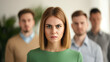 © fotogurme - High angle view of a woman facing workplace harassment, male colleagues laughing in the background