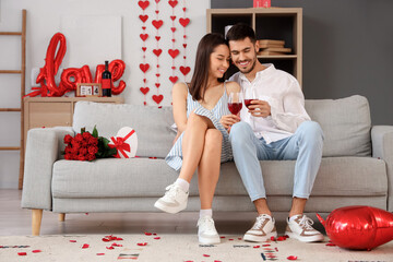 Wall Mural - Young couple drinking wine at home. Valentine's Day celebration