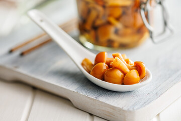 Wall Mural - Pickled nameko mushrooms.Traditional japanese mushrooms in ceramic spoon on white table.