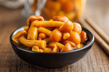 Wall Mural - Pickled nameko mushrooms.Traditional japanese mushrooms in bowl on wooden table.