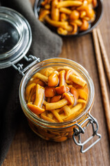 Wall Mural - Pickled nameko mushrooms.Traditional japanese mushrooms in jar on wooden table.