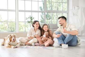 Poster - Happy family with paint color palettes and dog during repair of their new house