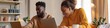 © Andrii Zastrozhnov - A man and a woman are sitting on a couch, both using laptops. The woman is smiling and the man is looking at his laptop. Concept of relaxation and leisure