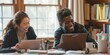 © Andrii Zastrozhnov - Two people are sitting at a table with laptops and smiling. They seem to be enjoying each other's company while working on their laptops