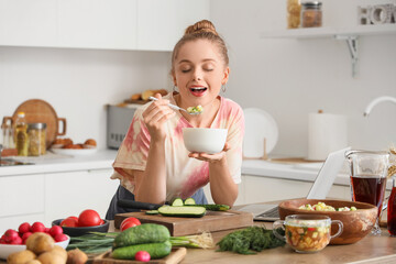 Canvas Print - Young woman eating tasty okroshka in kitchen