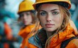 © imagineRbc - Two young women in orange safety jackets and hard hats focus on their tasks at a construction site, showcasing their professionalism in a challenging environment