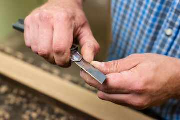 A carpenter sharpens a pencil