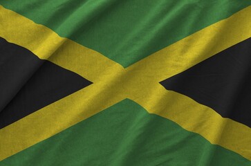 Wall Mural - Jamaica flag depicted on folded wavy fabric of old cloth close up