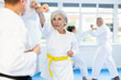 © JackF - Sportive old-aged woman trainee of karate courses applying attack methods on her partner