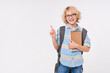 © InsideCreativeHouse - Smart preteen boy male child kid elementary primary middle school pupil teenager in eyeglasses with backpack holding copybooks pointing index finger up at copy space isolated over white background