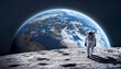 © edu_mngs - Silhouette of an astronaut walking on the lunar surface with the planet Earth behind him.