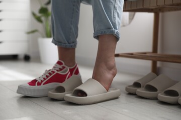 Wall Mural - Woman changing into slippers at home, closeup