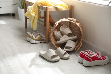 Wall Mural - Basket with slippers for guests and sneakers in entryway at home