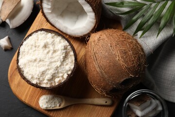 Organic coconut flour and fresh fruits on black table, flat lay