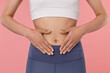 © New Africa - Healthy digestion. Woman touching her belly on pink background, closeup