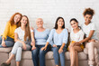 © Prostock-studio - Group Of Diverse Women Smiling At Camera Sitting On Couch Against White Wall Indoor. Equality Concept