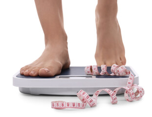 Canvas Print - Diet and weight loss concept. Woman on floor scale and measuring tape against white background, closeup