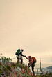 © peopleimages.com - Space, helping hand and friends hiking with support for climbing on mountain or hill in nature. Mockup, walking and hikers on adventure for assistance, travel and freedom of teamwork, sky and trust