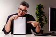 © Giulio_Fornasar - Smiling professional pointing at blank clipboard in office