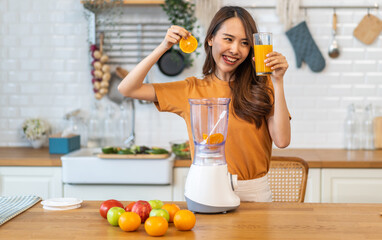 Wall Mural - Portrait of beauty healthy asian woman making orange fruit smoothie with blender.girl preparing cooking detox cleanse with fresh orange juice in kitchen at home.health, vitamin c, diet, healthy drink