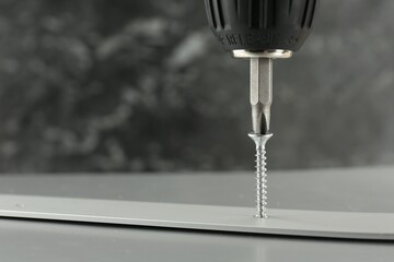 Canvas Print - Screwing screw into white panel at light table, closeup. Space for text