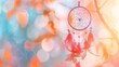 © Maria - A delicate dream catcher hangs gracefully against a softly blurred, colorful backdrop, creating a serene atmosphere