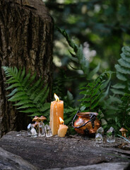 Sticker - witch cauldron, candles and qurtz crystals on stump in forest, abstract natural background. occult esoteric spiritual practice. wiccan magic ritual, witchcraft. fairytale, mystery atmosphere.