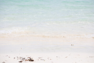 Sparkling waves hitting the shore on the beach, sand white background image. turquoise water, white sand, island