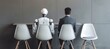 © MD Media - AI robot sitting on a chair next to an elderly man with coffee, both waiting for a job interview. AI vs human concept. futuristic technology coexisting with people in a professional environment