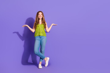 Sticker - Full body photo of attractive teen woman compare hold empty space dressed stylish green clothes isolated on violet color background