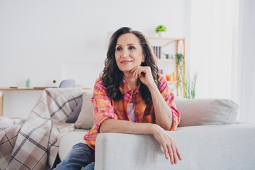 Poster - Photo of dreamy cheerful lady wear plaid shirt smiling sitting couch indoors room home house