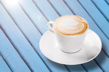 Wall Mural - Cup of tasty hot coffee on wooden desk